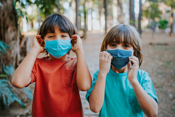 Smiling children behind protective masks