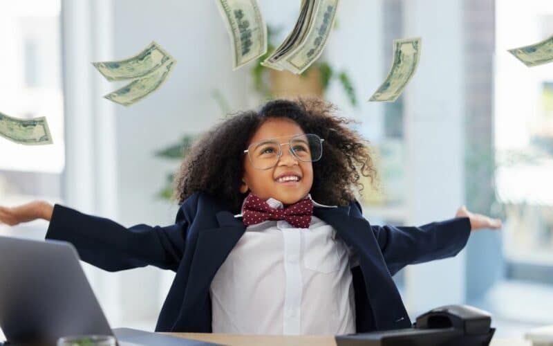 Kid in business suit throwing money in the air.