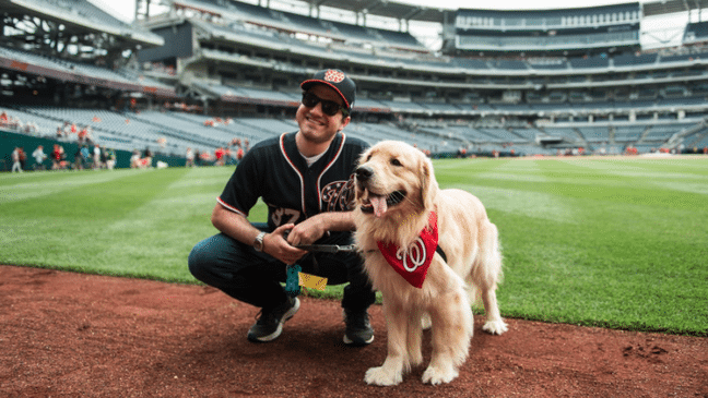 Man and dog posing on a baseball field